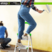 DIY enthusiasts using the durable StepIt by Rackit Direct ladder; woman in denim jeans and plaid shirt painting a wall, while another person in blue sits nearby, both emphasising the ladder's stability and functionality in home improvement tasks